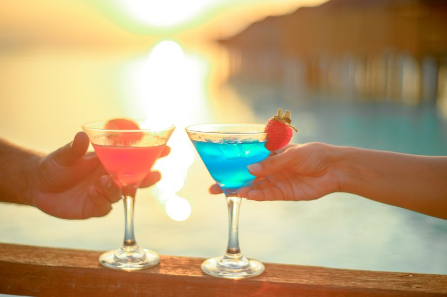 Tropical cocktails garnished with fruit, arranged on a bar counter