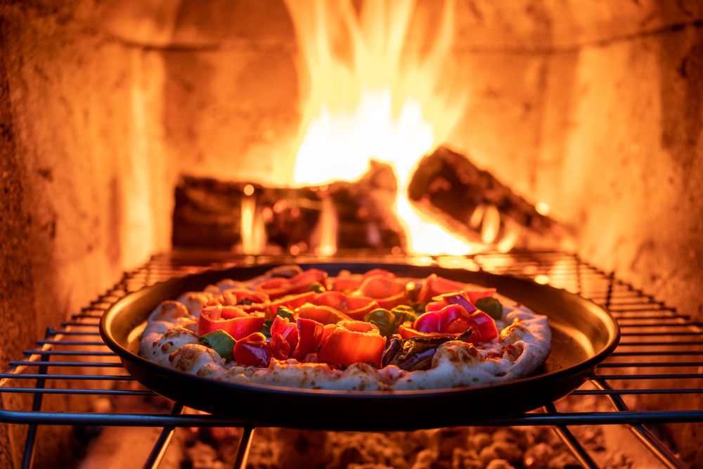 A freshly baked wood-fired pizza with charred crust and melted cheese