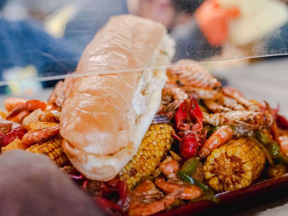 A platter of fresh seafood served on a rustic wooden table near the coast