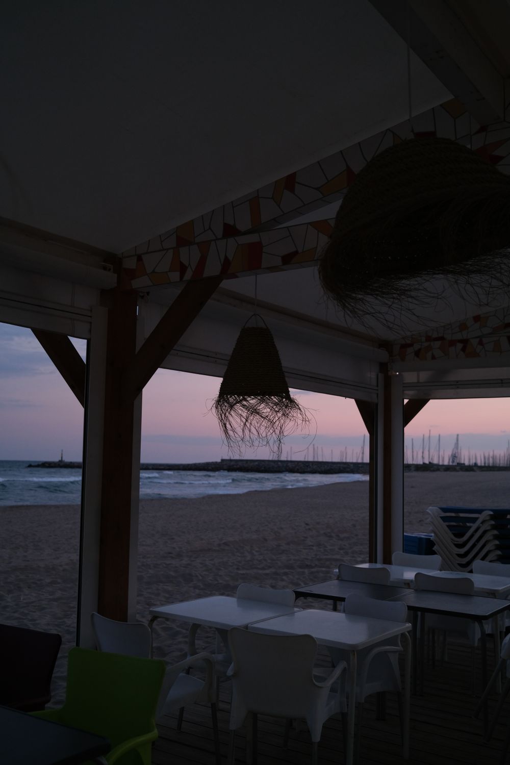 Outdoor beachfront dining area overlooking the ocean at golden hour
